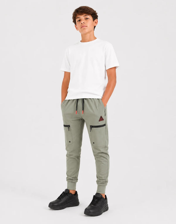 boy wearing white t shirt and olive green cargo trackpants with zip pockets and drawstring, black sneakers