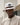 K-Star 7 Originals white wide brim bucket hat with brown band and chin strap, worn by man outdoors.