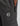 close up of dark grey trackpants with a zippered pocket and a hexagonal patch bearing the K Star logo.