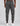 back view of grey cargo trackpants with elastic waistband, cargo pockets, and a small logo patch, worn with white sneakers