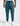 teal track pants with drawstring waist, cargo pockets, logo patch on thigh, cuffed ankles, worn with white sneakers
