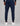 back view of navy track pants with rear patch pocket and side cargo pockets, cuffed hems, worn with white sneakers
