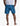 Back view of dark blue men's swimshorts featuring an all-over blue and teal leaf pattern, worn by a model.