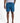 Men's blue leaf-patterned swim shorts with a visible K*7 logo patch and a drawstring, styled for a natural fit on a model.