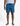 Men's blue leaf-patterned swim shorts with a visible K*7 logo patch and a drawstring, styled for a natural fit on a model.