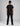 back view of a young boy wearing a plain black short sleeve t shirt and black pants against a grey studio backdrop