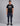 man wearing a black short sleeve t shirt with a white framed logo and navy cargo pants