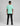 back view of a boy wearing a mint green short sleeve t shirt and black jeans against a grey studio backdrop