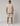 man in beige two piece set viewed from behind; short sleeve top and knee length shorts with navy trim