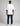 back view of a man wearing an oversized white short sleeve tee with a small black brand tag on the upper back, paired with